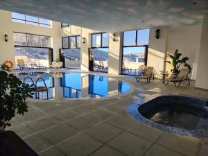 a swimming pool in a building with tables and chairs at H Luxury Hotel in Wadi Musa