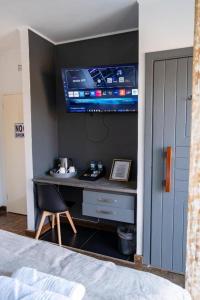 una camera da letto con scrivania e TV a parete di 133onFifth a Umtali Altre 24 foto