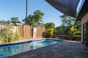 a swimming pool in a backyard with a wooden fence at 133onFifth in Umtali