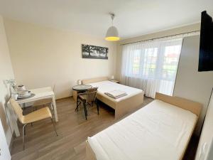 een slaapkamer met een bed, een bureau en een tafel bij pensjonat KAJA 200 metrów od morza in Międzyzdroje