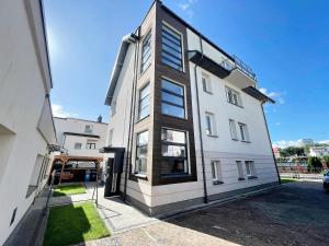 een hoog wit gebouw met ramen aan een straat bij pensjonat KAJA 200 metrów od morza in Międzyzdroje