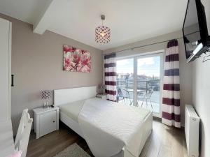 een slaapkamer met een wit bed en een balkon bij pensjonat KAJA 200 metrów od morza in Międzyzdroje