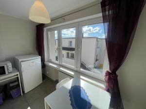 een kamer met een raam, een tafel en een magnetron bij pensjonat KAJA 200 metrów od morza in Międzyzdroje