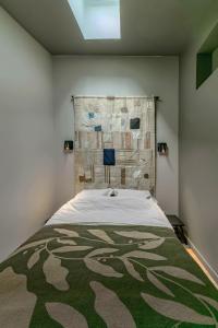 a bedroom with a bed with a blanket on it at Le Bompart - Petite maison design et confortable proche centre in Clermont-Ferrand