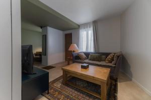 a living room with a couch and a coffee table at Le Bompart - Petite maison design et confortable proche centre in Clermont-Ferrand