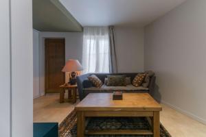 a living room with a couch and a table at Le Bompart - Petite maison design et confortable proche centre in Clermont-Ferrand