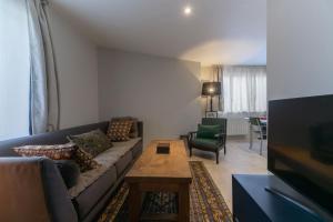 a living room with a couch and a table at Le Bompart - Petite maison design et confortable proche centre in Clermont-Ferrand +25 photos