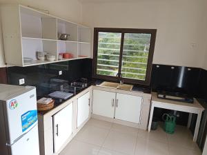 a kitchen with white cabinets and a sink and a window at MiMi24 in Mahajanga