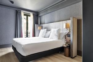 ein Schlafzimmer mit einem großen weißen Bett und einem Fenster in der Unterkunft One Shot Luchana in Madrid