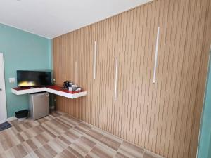 een kamer met een houten muur en een tv. bij คุณเก้า รีสอร์ท in Non Sa-at +24 foto's