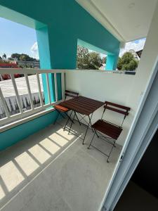 een balkon met 2 stoelen en een houten tafel bij Three Monkeys Chaweng Beach in Nathon Bay