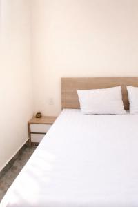 ein weißes Bett mit zwei Kissen darüber in der Unterkunft Bảo Ngọc Hotel Đông Hà in Quang Tri