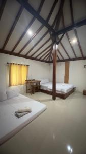 una grande stanza con due letti e un tavolo di Tamu Agung Wonosari a Wonosari