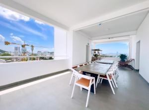 a dining room with a table and chairs and a large window at Quy Nhon Sea Hotel in Quy Nhon