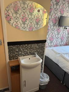 een kleine badkamer met een wastafel en een bed bij The Clarendon Hotel in Blackpool