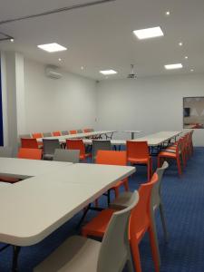 een leeg klaslokaal met tafels en oranje stoelen bij Hotel Star Express Puebla in Puebla