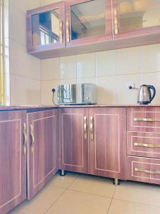 een keuken met houten kasten en een pot op het aanrecht bij Kingston apartment in Kigali