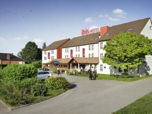 een groot wit gebouw met een boom ervoor bij ibis Charleroi Airport Brussels South in Charleroi