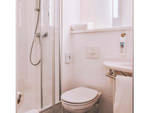 a bathroom with a shower and a toilet and a sink at ibis Hotel Frankfurt Airport in Kelsterbach +76 photos