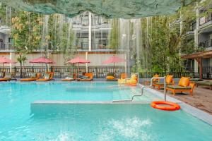 een zwembad bij een hotel met stoelen en parasols bij Phuvaree Resort in Patong Beach +71 foto's