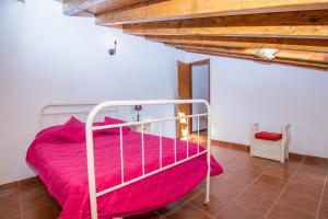 1 dormitorio con cama con sábanas rosas y techo de madera en Akivillas Lagos Quiet, en Barão de São Miguel