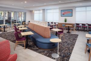 - une salle d'attente avec un canapé, des tables et des chaises dans l'établissement Home2 Suites By Hilton Memphis Downtown, à Memphis