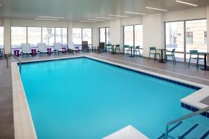 une grande piscine avec chaises et tables dans l'établissement Home2 Suites By Hilton Memphis Downtown, à Memphis