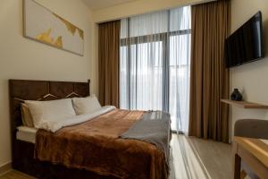 a hotel room with a bed and a large window at Roomook Cozy studio in Dubai