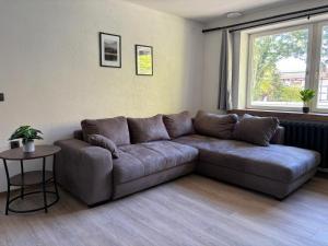 a brown couch in a living room with a window at Hotel Mühlental in Wernigerode +32 photos