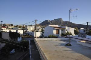 a view of a city with white buildings and mountains at Pension Annoula in Archangelos