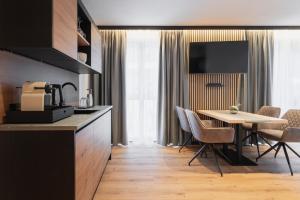 a kitchen and dining room with a table and chairs at Falcon Suites Pure - Summercard included in Kaprun