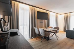 a kitchen and living room with a table and chairs at Falcon Suites Pure - Summercard included in Kaprun