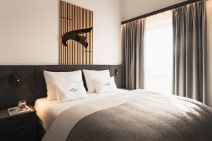 a bedroom with a large white bed with a window at Falcon Suites Pure - Summercard included in Kaprun