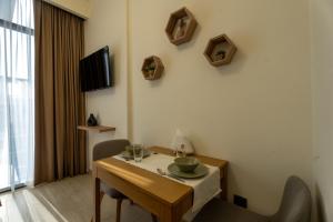 a room with a table and chairs and a television at Roomook Cozy studio in Dubai