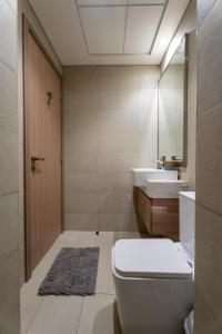 a bathroom with a toilet and a sink and a mirror at Roomook Cozy studio in Dubai +22 photos