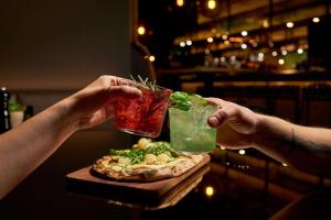 two people are holding up drinks on a table at Cocoon Sendlinger Tor in Munich