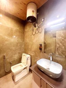 ein Badezimmer mit Toilette und Waschbecken in der Unterkunft Queen Hills Resort and Hotel By Edge Group - Rooftop Restro, Balcony View in Masuri