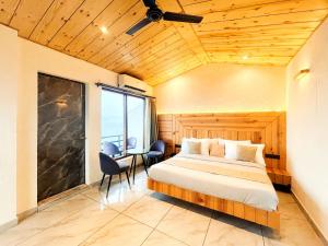 ein Schlafzimmer mit einem Bett und einem Schreibtisch in einem Zimmer in der Unterkunft Queen Hills Resort and Hotel By Edge Group - Rooftop Restro, Balcony View in Masuri