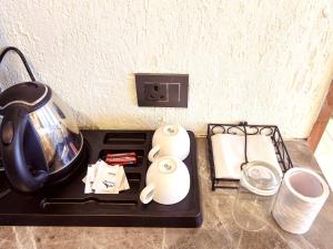 a stove top with a tea kettle and paper towels at Living On The Edge A Luxury Stay in Mussoorie in Mussoorie