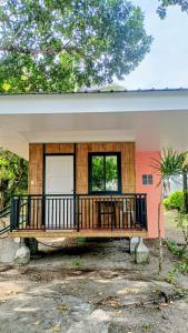 a house with a large deck in front of it at Suki Beach Resort Beachfront Cottage in Santa Magdalena