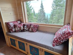 a window seat in a tiny house with pillows at Mountain Cabin on Dobrča - Alpine Views -Foot Access Only in Tržič