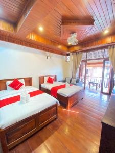 een kamer met twee bedden en een bank erin bij Villa Xiengthong Garden View in Luang Prabang