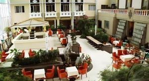 un patio extérieur avec des tables et des chaises dans un bâtiment dans l'établissement Lhasa Hotel, à Lhasa
