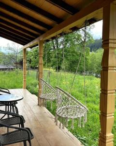 a porch with two chairs and a swing at Cozy Rest House in Verkhovyna +8 photos