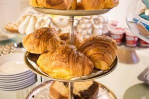a tray of croissants and pastries on a stand at Hotel Ariston in Livorno