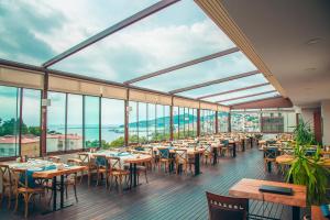 a restaurant with tables and chairs and large windows at Kelesler Park Hotel in Ereğli
