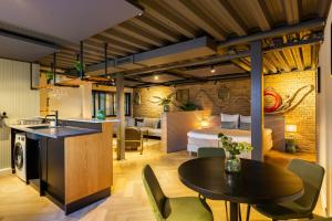 een keuken en woonkamer met een tafel en stoelen bij Hotel Maassluis in Maassluis