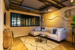 een woonkamer met een bank en een bakstenen muur bij Hotel Maassluis in Maassluis