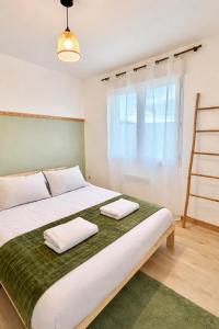 a bedroom with a large white bed with two towels at Maison entiere jacuzzi reception ouverte 7 7j et 24 24h in Ambarès-et-Lagrave +22 photos