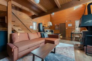 een woonkamer met een bruine bank en een tafel bij Mokurie in Teshikaga